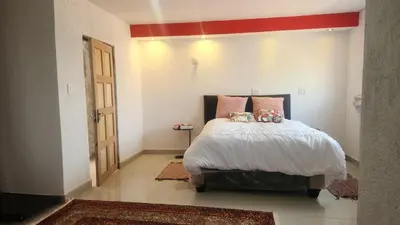 a bedroom with a bed with a red stripe on the wall at GenAyah Hotel & Safari in Mtimba