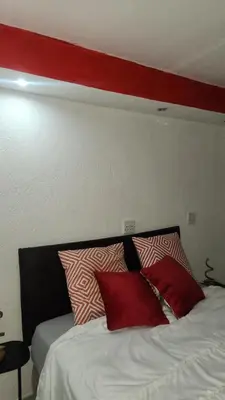 a red stripe above a bed with red pillows at GenAyah Hotel & Safari in Mtimba