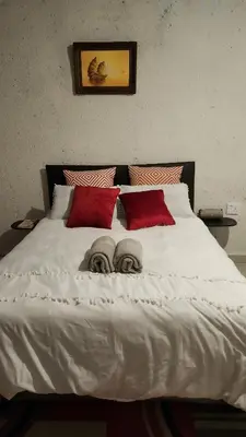 a large white bed with two people laying on it at GenAyah Hotel & Safari in Mtimba