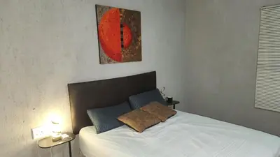 a bedroom with a white bed with two pillows at GenAyah Hotel & Safari in Mtimba