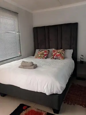 a bedroom with a large bed with white sheets and pillows at GenAyah Hotel & Safari in Mtimba