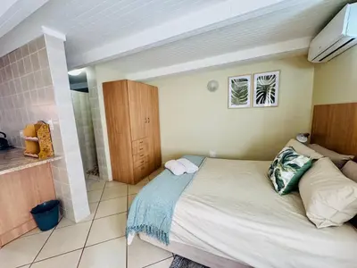 a bedroom with a large bed and a bathroom at The Well, Mokopane in Mokopane
