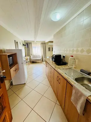 a kitchen with a sink and a refrigerator at The Well, Mokopane in Mokopane