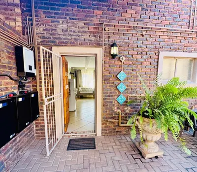 a brick building with a door and a plant at The Well, Mokopane in Mokopane