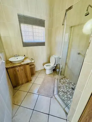 a bathroom with a toilet and a shower and a sink at The Well, Mokopane in Mokopane