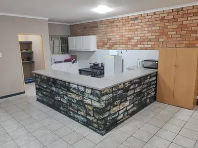 a kitchen with a brick wall and a counter top at I&S apartments & rentals in Burgersfort