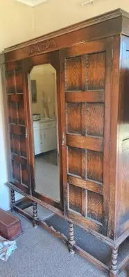 a wooden cabinet with a mirror in a room at I&S apartments & rentals in Burgersfort