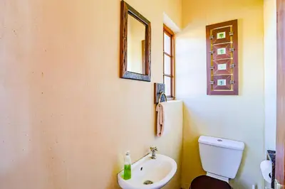 a bathroom with a white toilet and a sink at Bush Lodge Retreat Villa 29 in Warmbaths