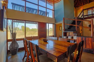 a dining room with a wooden table and chairs at Bush Lodge Retreat Villa 29 in Warmbaths