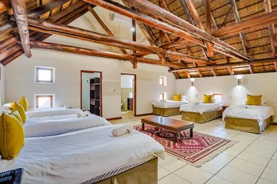 a large room with two beds and a table at Amani Lodge - Villa 81 in Warmbaths