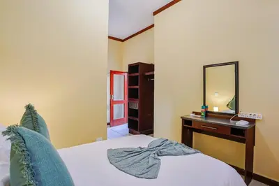 a bedroom with a bed and a vanity with a mirror at Amani Lodge - Villa 81 in Warmbaths