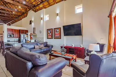 a living room with couches and a table at Amani Lodge - Villa 81 in Warmbaths
