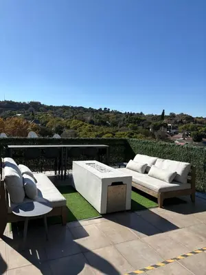 a patio with two couches and a table and chairs at Nare Penthouse in Pretoria