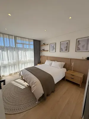 a bedroom with a large bed and a large window at Nare Penthouse in Pretoria