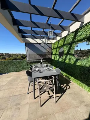 a patio with a table and chairs under awning at Nare Penthouse in Pretoria