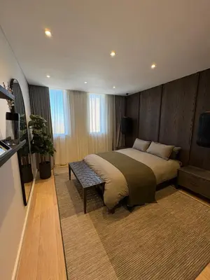 a bedroom with a bed and a bench in it at Nare Penthouse in Pretoria