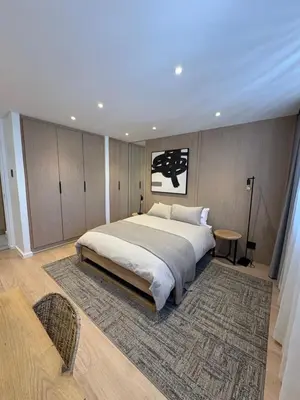 a bedroom with a large bed and a rug at Nare Penthouse in Pretoria