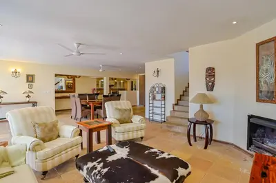 a living room with two chairs and a fireplace at Stunning Bushveld Villa 84 in Warmbaths