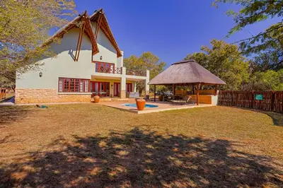 a house with a gazebo in a yard at Stunning Bushveld Villa 84 in Warmbaths