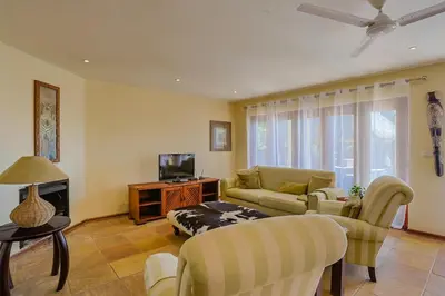 a living room with a couch and a tv at Stunning Bushveld Villa 84 in Warmbaths