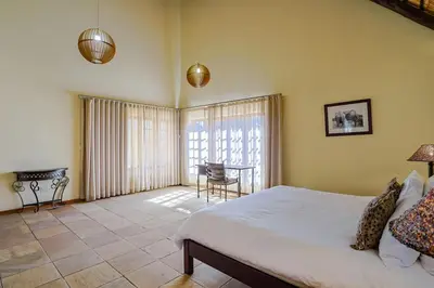 a bedroom with a bed and a table and a chair at Stunning Bushveld Villa 84 in Warmbaths