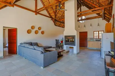 a living room with a blue couch and a kitchen at Stunning Bushveld Villa 84 in Warmbaths