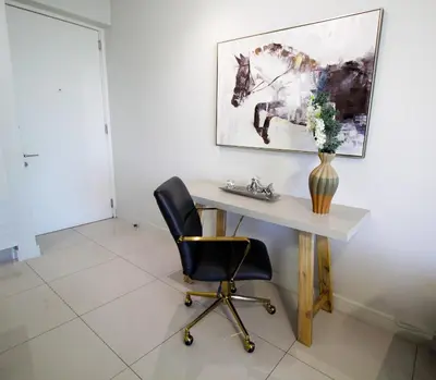 a desk in a room with a vase of flowers on it at 1Bed Stylish Apartment - Waterfall in Midrand