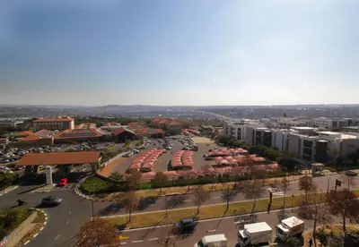 an aerial view of a city with a parking lot at 1Bed Stylish Apartment - Waterfall in Midrand