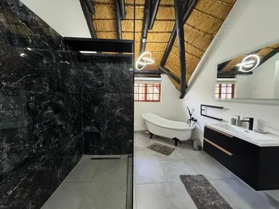 a bathroom with a bath tub and a sink at Golden Casa in Mokopane