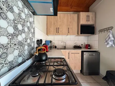 a kitchen with a stove top oven in a kitchen at Golden Casa in Mokopane