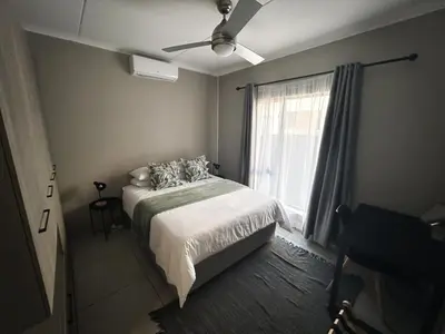 a bedroom with a bed and a window at The Grey Oasis in Tzaneen