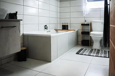 a bathroom with a tub and a toilet at The Grey Oasis in Tzaneen