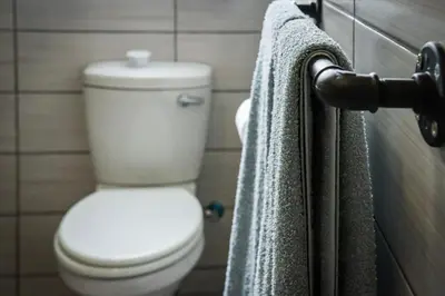 a bathroom with a toilet and two towels at The Grey Oasis in Tzaneen