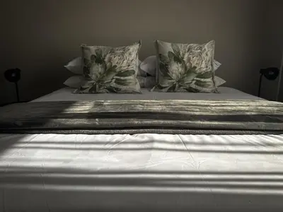 a bed with two pillows and a blanket on it at The Grey Oasis in Tzaneen