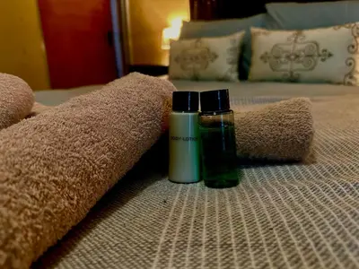 a bottle of soap and towels on a bed at Nkandla Yethu Guest House in Nelspruit
