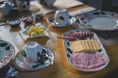 a wooden table topped with plates and bowls of food at Thokozani Lodge in White River