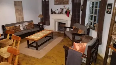 a living room filled with furniture and a fireplace at Thokozani Lodge in White River