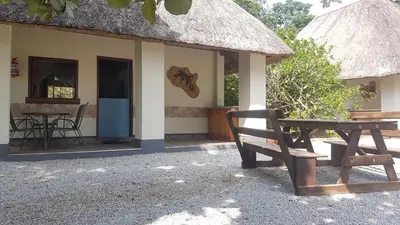 a building with a table and a bench in front of it at Thokozani Lodge in White River