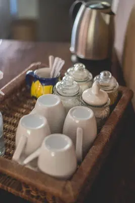 a tray with cups and dishes on a table at Thokozani Lodge in White River