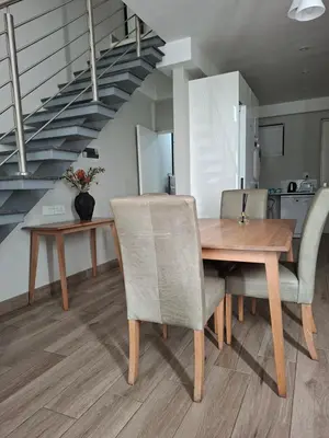 a dining room with a table and chairs and a staircase at Luxurious Loft in Pretoria