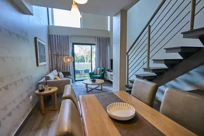 a living room with a table and a staircase at Luxurious Loft in Pretoria