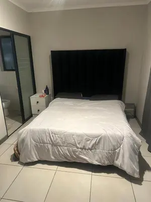 a bed with a black headboard in a bedroom at The Parks in Midrand