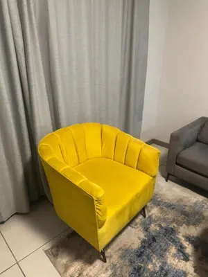 a yellow chair in a living room with a window at The Parks in Midrand