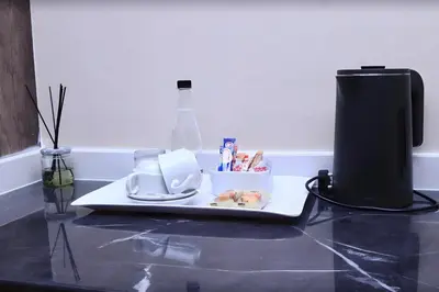 a table with a plate with a coffee maker on it at Masana Hotels in Polokwane
