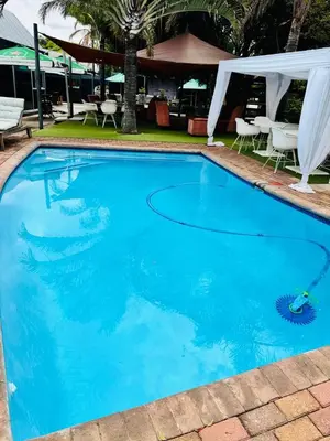 a large blue swimming pool with a gazebo at Masana Hotels in Polokwane