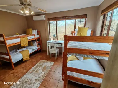 a room with three bunk beds and a desk at Lion's Pride - Marloth Park in Marloth Park