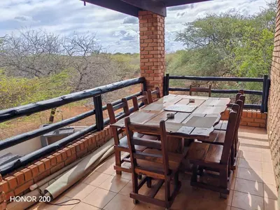 a table and chairs on a balcony with a view at Lion's Pride - Marloth Park in Marloth Park