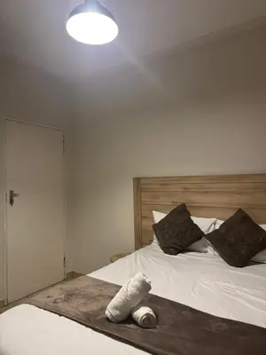 a bedroom with a bed with a stuffed animal on it at Midrand Apartment near Mall of Africa in Midrand