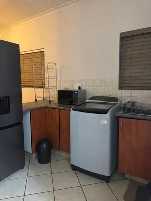 a kitchen with a dishwasher and a washer at Midrand Apartment near Mall of Africa in Midrand