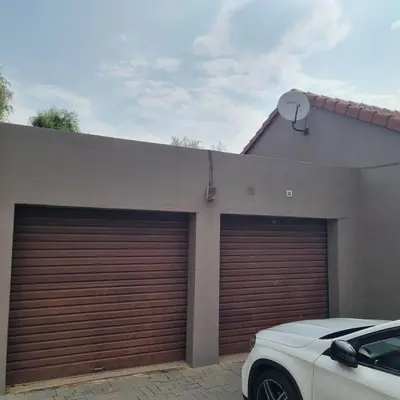 two garage doors in front of a house at Midrand Apartment near Mall of Africa in Midrand